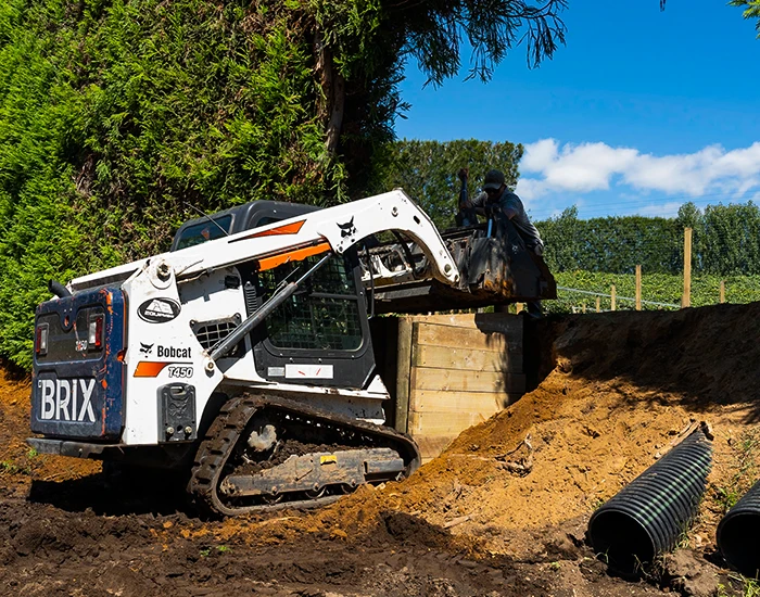 Brix branded bobcat moving earth to make way for load pad on Tauranga orchard