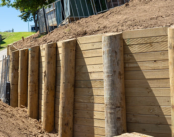Retaining wall built using sturdy timber posts and horizontal timber planks
