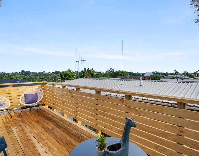 Outdoor living space with table and chairs, showing a recent timber decking and fence project in Welcome Bay, Tauranga.