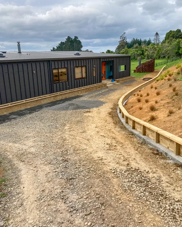 Sloped driveway with retaining wall on one side, the surface has been prepped for concrete lay by Brix Construction